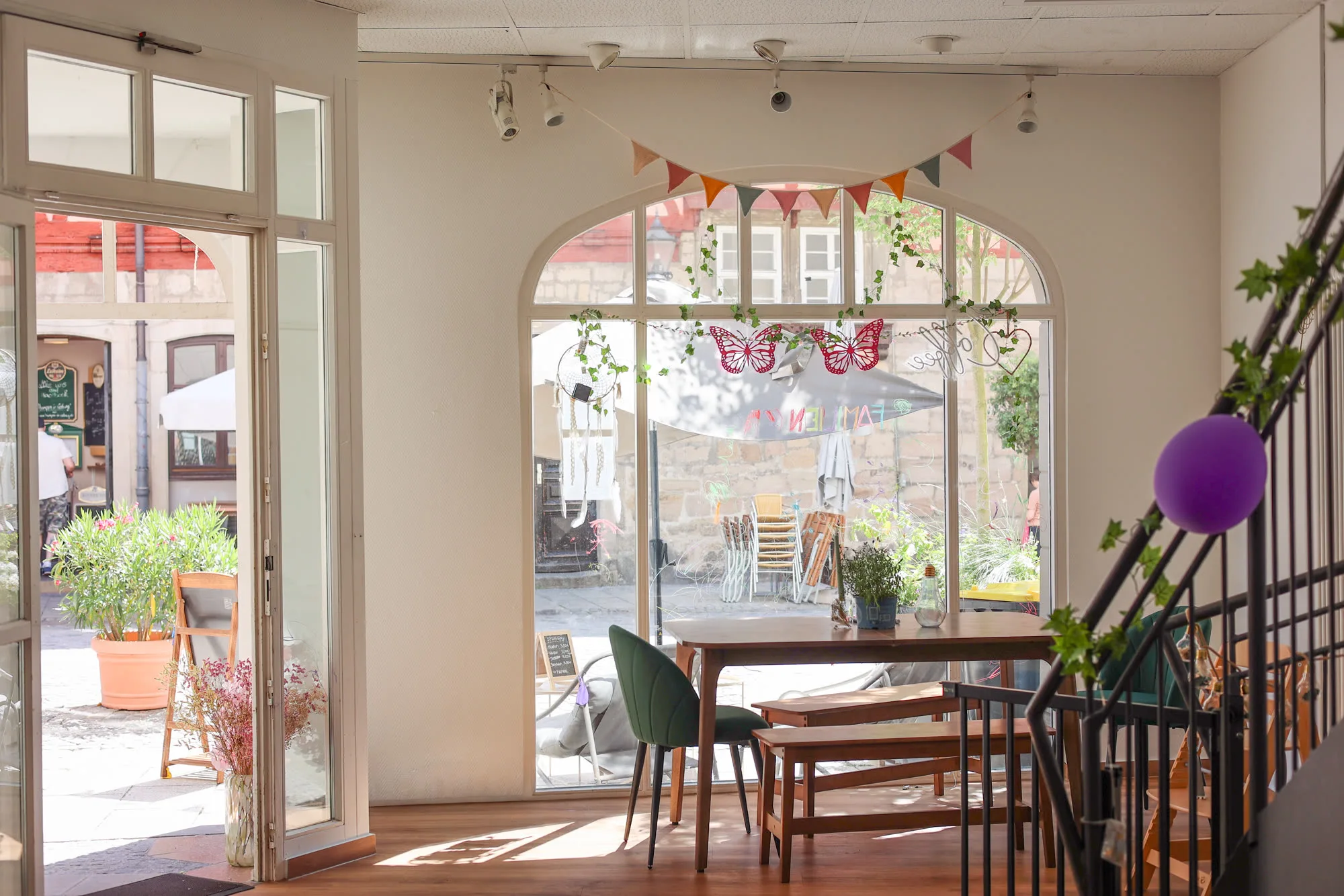 Familiencafé Goldkrümel – Gastraum mit Rundbogentür zur Terrasse