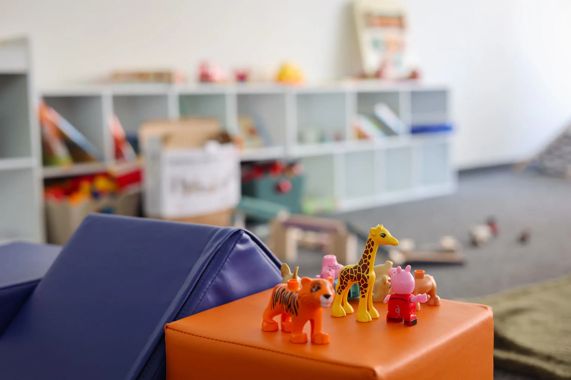 Familiencafé Goldkrümel – Spielbereich mit Spielzeugregalen und Spielteppich